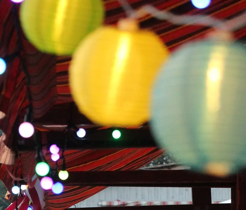 Bunte Lampions und Lichter unter einem Festzelt.